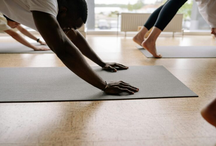 Close-up of man's hands in Downward Facing Dog in yoga class.