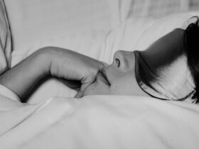 Woman resting in bed after doing yoga for sleep.