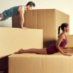 Four people demonstrating yoga for strength against a backdrop of boxes