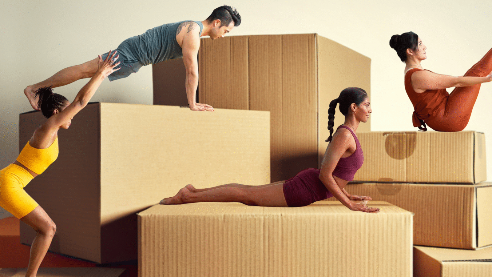 Four people demonstrating yoga for strength against a backdrop of boxes