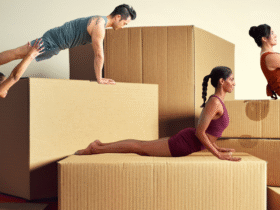 Four people demonstrating yoga for strength against a backdrop of boxes