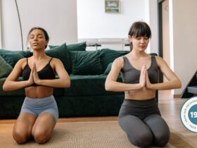 Two women practicing yoga at home.