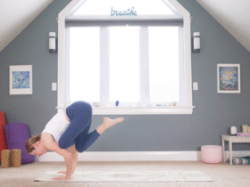 Woman leaning forward into the arm balance known as Flying Pigeon Pose