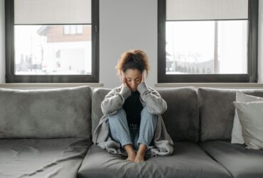 Woman grieving on couch.
