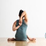 Man practicing Cow Face pose.