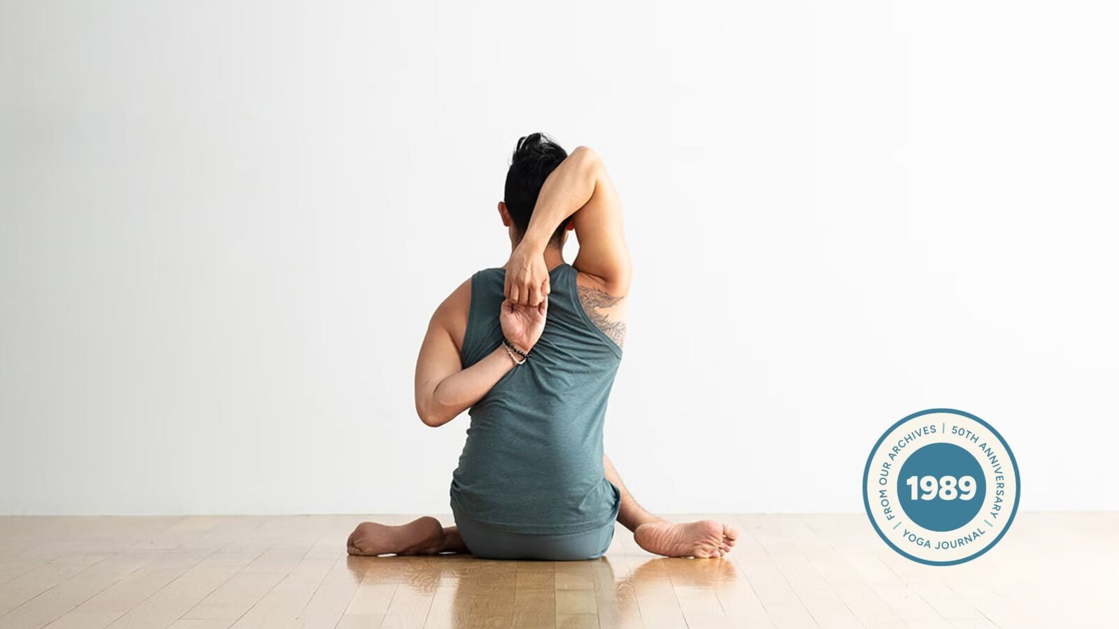 Man practicing Cow Face pose.