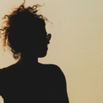 Silhouette of a woman at sunset considering the weekly horoscope for April 26-May 2, 2026.