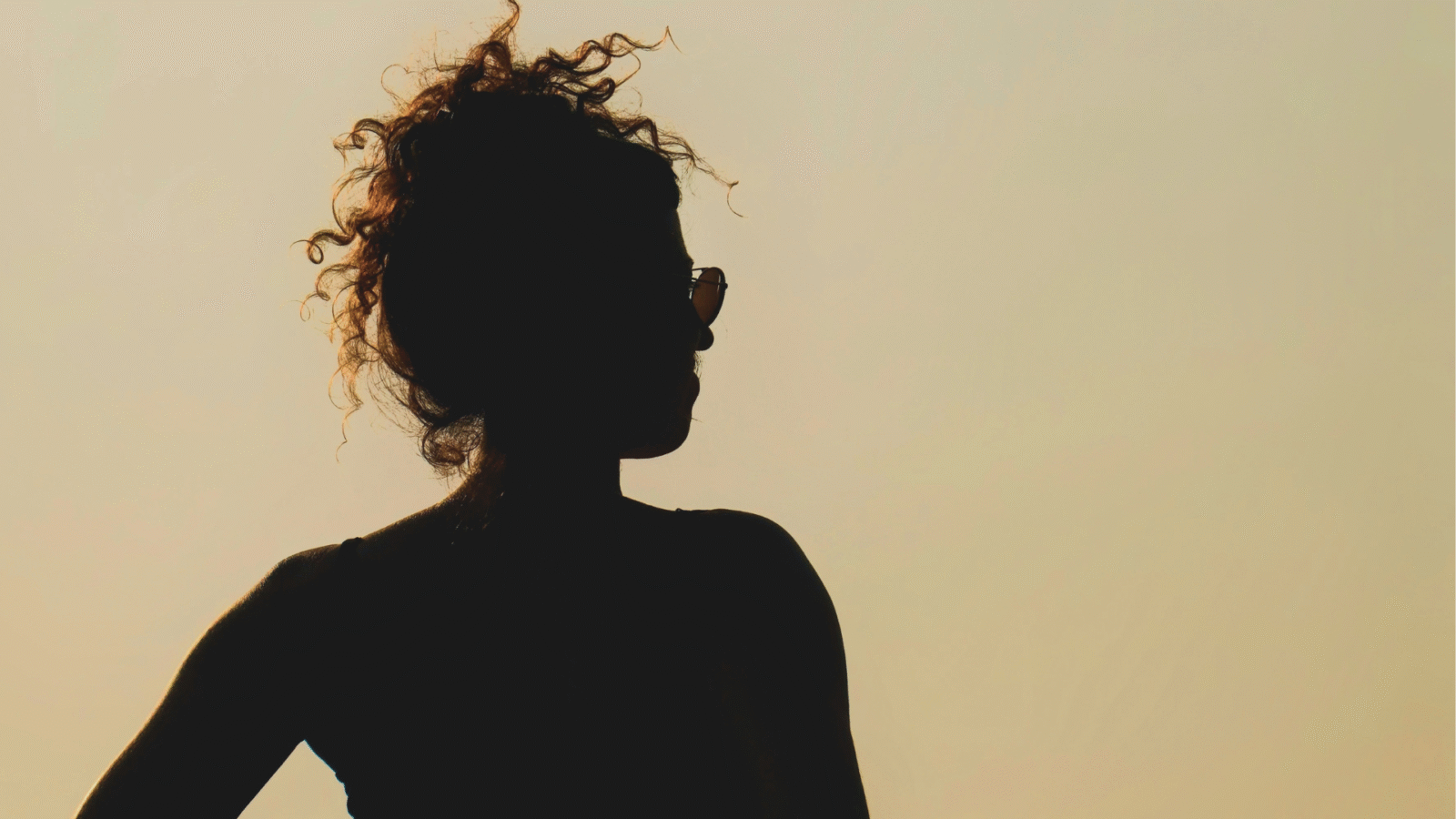 Silhouette of a woman at sunset considering the weekly horoscope for April 26-May 2, 2026.