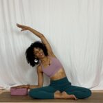 Yoga instructor practicing seated side stretch.