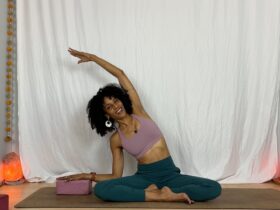 Yoga instructor practicing seated side stretch.