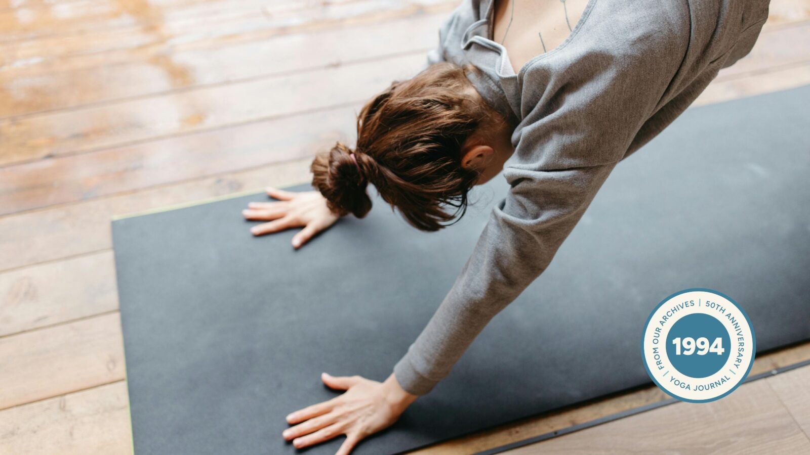 Woman practicing Downward Facing Dog for tight shoulders.