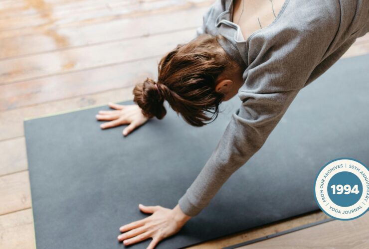 Woman practicing Downward Facing Dog for tight shoulders.