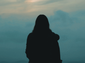 Woman staring into the greenish cast of a sunset while contemplating the weekly horoscope for April 12-18, 2026