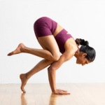 A woman coming into Crow Pose, one of the most popular arm balances