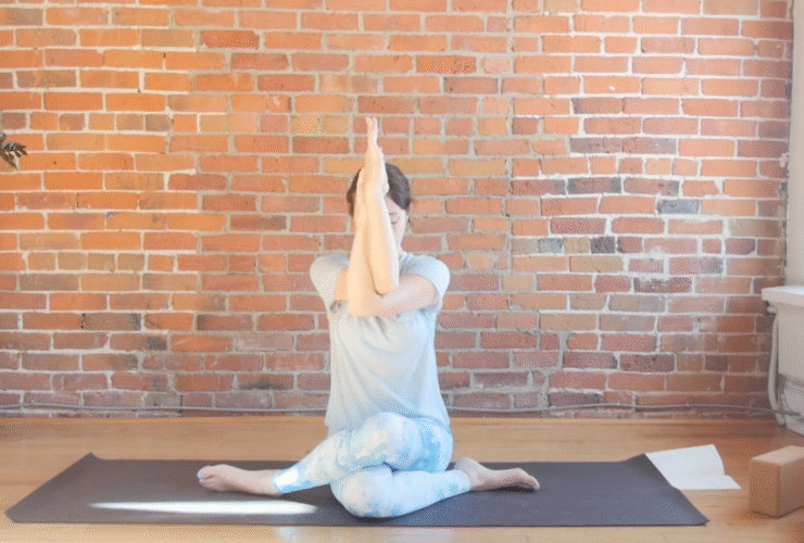 Woman sitting on a mat with her arms in front of her