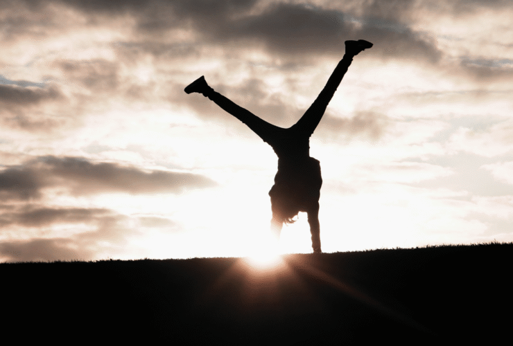 Woman turning cartwheels against a backdrop of the sunset